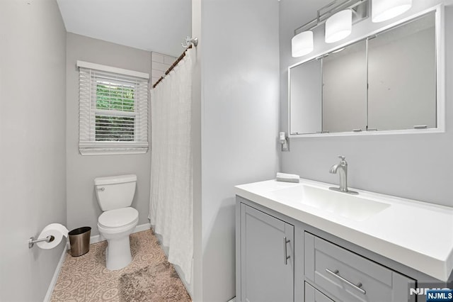 bathroom featuring vanity, baseboards, toilet, and tile patterned flooring
