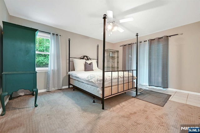 carpeted bedroom with baseboards and a ceiling fan