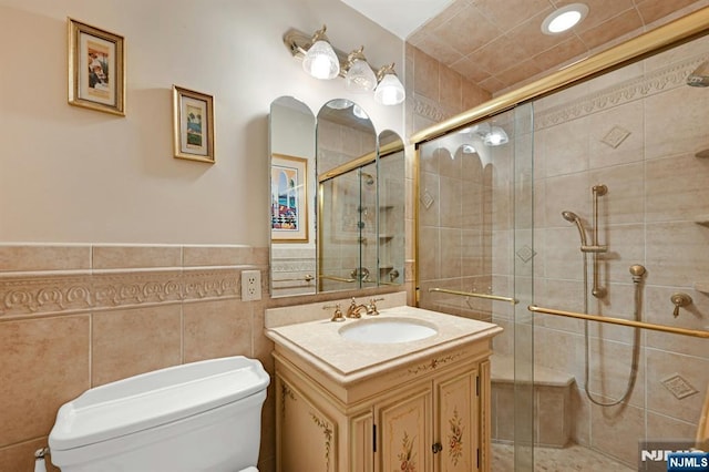 bathroom with vanity, toilet, and a stall shower