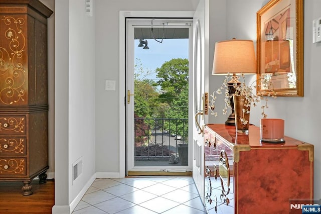 entryway featuring baseboards, tile patterned floors, and visible vents