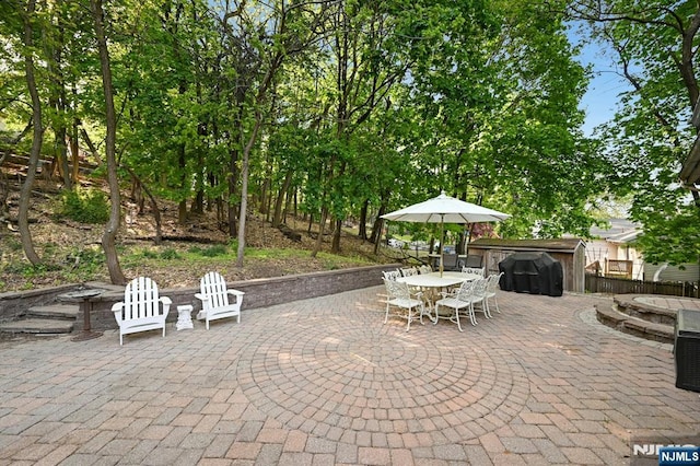 view of patio with outdoor dining area, an outdoor fire pit, and fence