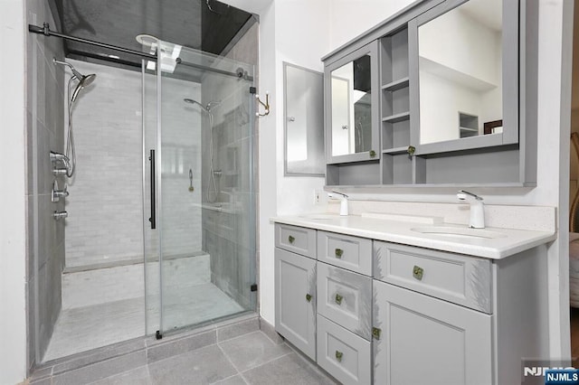 full bath with double vanity, a sink, tile patterned flooring, and a stall shower