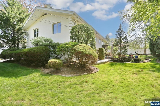 view of home's exterior with a lawn and stucco siding