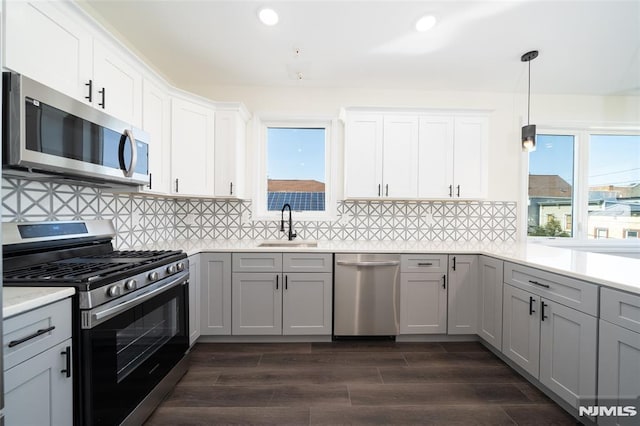kitchen with plenty of natural light, a sink, appliances with stainless steel finishes, and light countertops