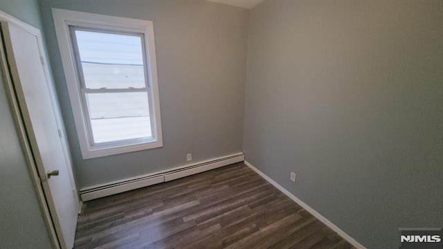 unfurnished room with baseboards, baseboard heating, and dark wood-style floors