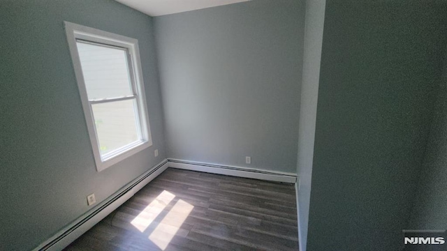 spare room featuring baseboards, a baseboard radiator, a wealth of natural light, and wood finished floors