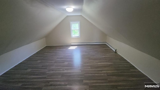 additional living space with a baseboard radiator, vaulted ceiling, and dark wood-type flooring