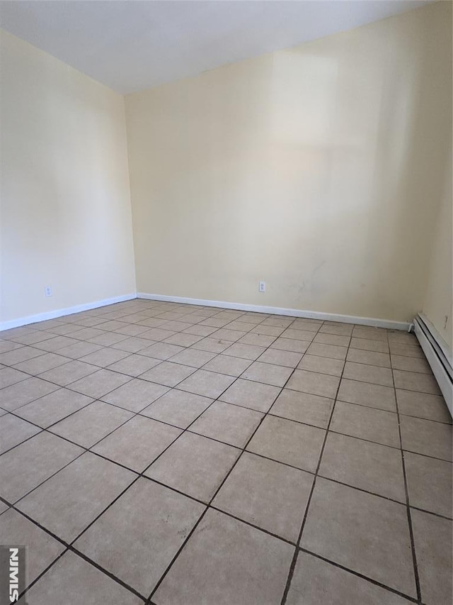 spare room with light tile patterned flooring and baseboards