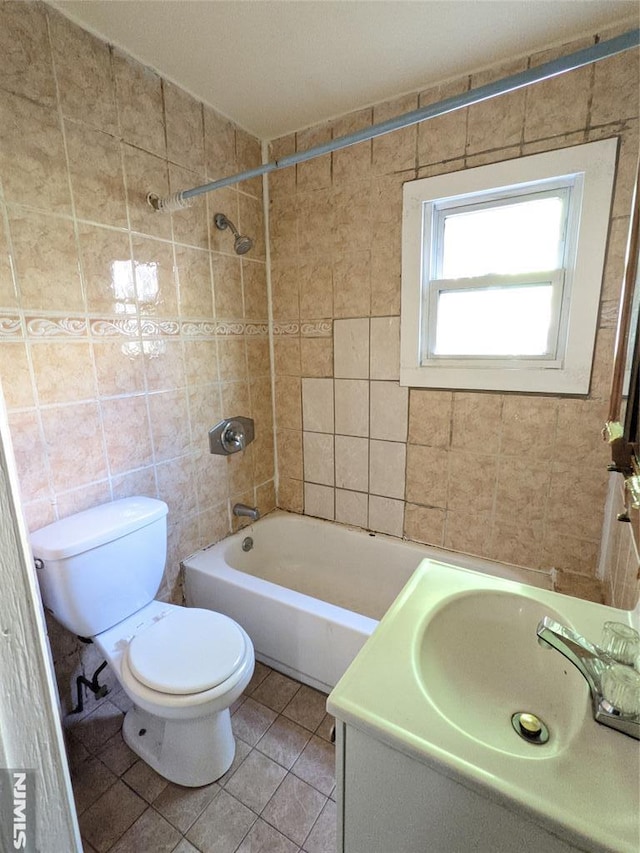 bathroom with vanity, toilet, tile walls, shower / tub combination, and tile patterned floors
