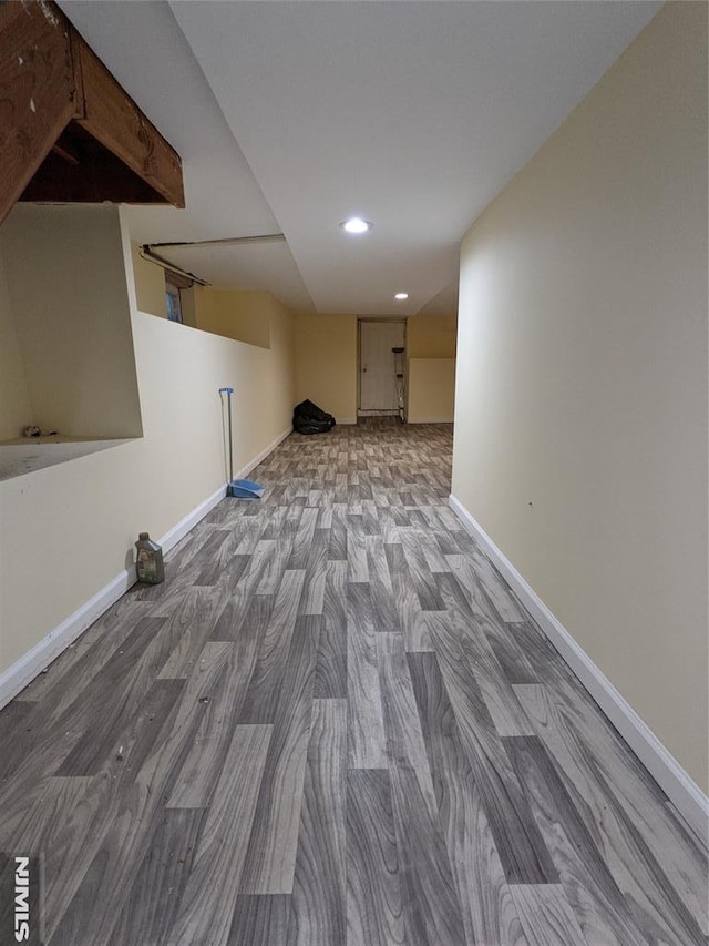 finished below grade area featuring baseboards, recessed lighting, and wood finished floors