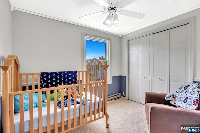 bedroom with a baseboard radiator, carpet, a closet, and ceiling fan