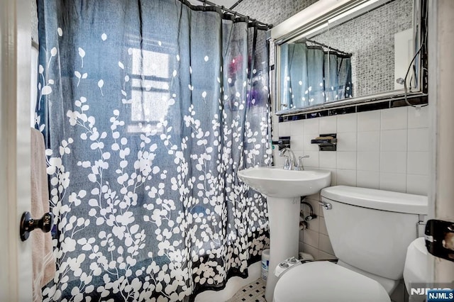 full bathroom featuring backsplash, toilet, and tile walls