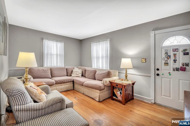 living area featuring baseboards and light wood-style flooring
