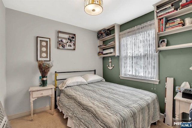 bedroom with carpet flooring, baseboards, and multiple windows