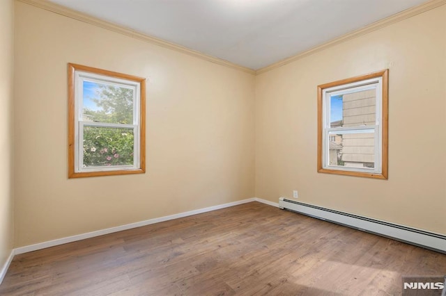 unfurnished room featuring crown molding, baseboards, baseboard heating, and wood finished floors