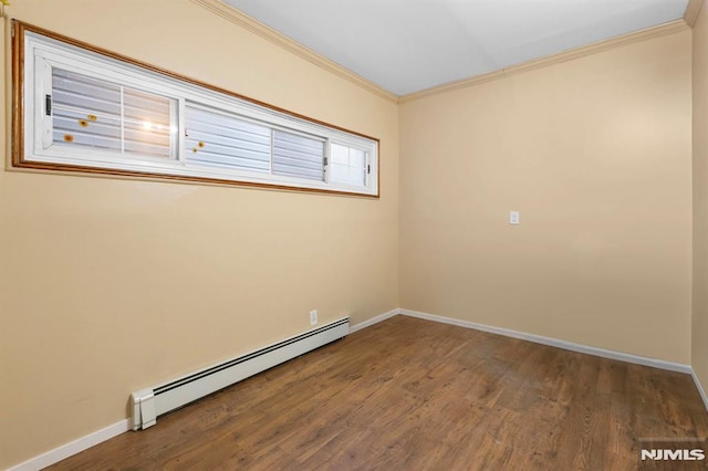 empty room featuring crown molding, baseboards, baseboard heating, and wood finished floors