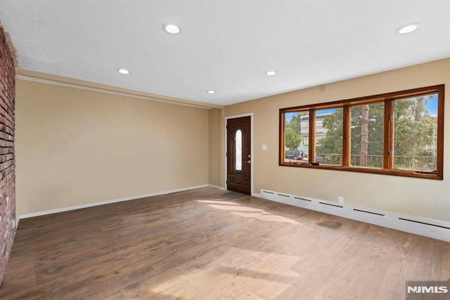 foyer entrance featuring recessed lighting, a baseboard radiator, baseboards, and wood finished floors