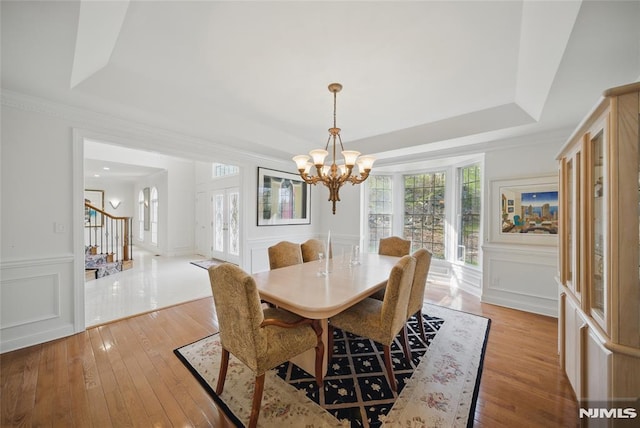 143 S Glen Rd, Kinnelon Borough, NJ 07405 - dining area with a tray ceiling, a decorative wall, light wood-style flooring, and a chandelier