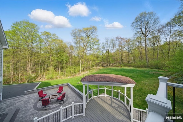143 S Glen Rd, Kinnelon Borough, NJ 07405 - wooden terrace featuring a yard, a view of trees, a fire pit, and a patio area