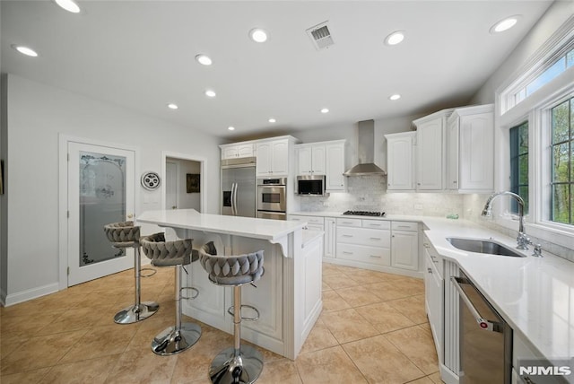 143 S Glen Rd, Kinnelon Borough, NJ 07405 - kitchen featuring wall chimney range hood, visible vents, a sink, stainless steel appliances, and white cabinetry