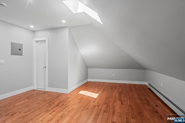 1026 Grove St, Irvington, NJ 07111 - bonus room featuring vaulted ceiling with skylight, electric panel, a baseboard radiator, light wood finished floors, and recessed lighting