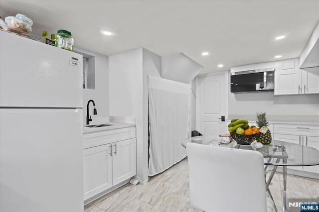 1026 Grove St, Irvington, NJ 07111 - kitchen with freestanding refrigerator, stainless steel microwave, a sink, and white cabinets