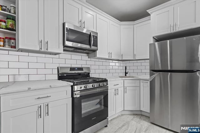 1026 Grove St, Irvington, NJ 07111 - kitchen featuring decorative backsplash, white cabinetry, light stone counters, a sink, and appliances with stainless steel finishes