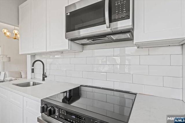 1026 Grove St, Irvington, NJ 07111 - kitchen featuring a sink, white cabinetry, appliances with stainless steel finishes, and light countertops