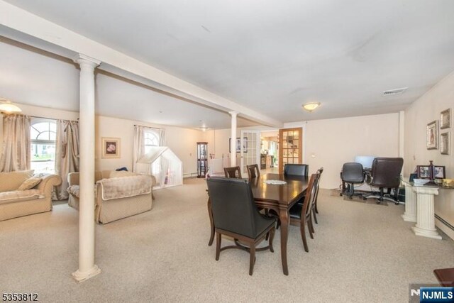 carpeted dining area with decorative columns and a healthy amount of sunlight