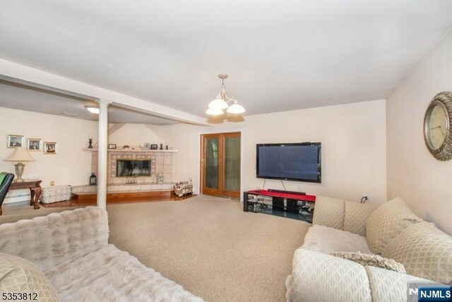 living area with an inviting chandelier and a tile fireplace