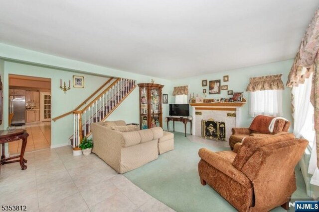 living room featuring stairway, tile patterned flooring, and a fireplace