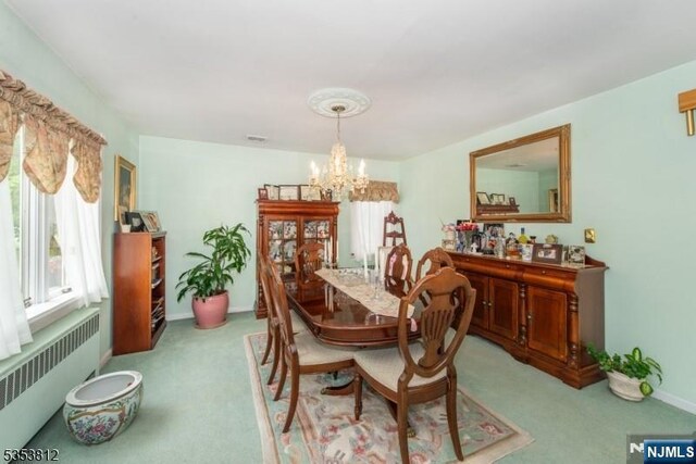 dining area with light colored carpet, baseboards, an inviting chandelier, and radiator heating unit