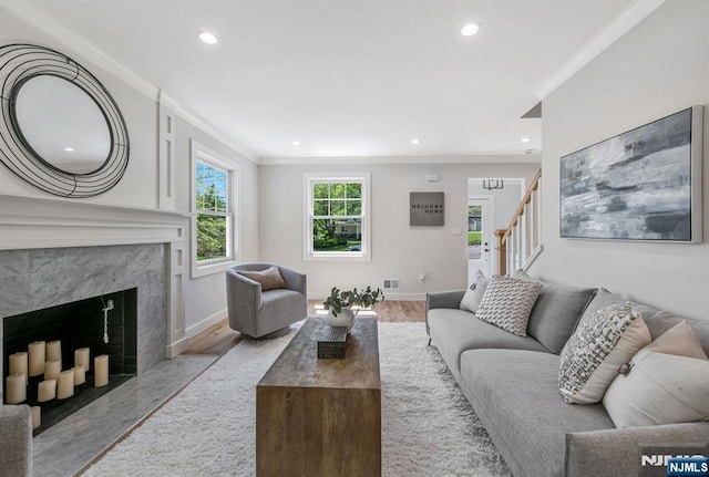 living room with crown molding, recessed lighting, wood finished floors, and stairway