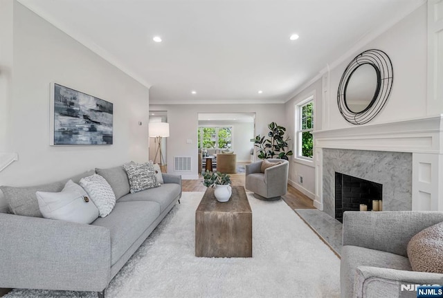 living area featuring crown molding, recessed lighting, visible vents, and wood finished floors
