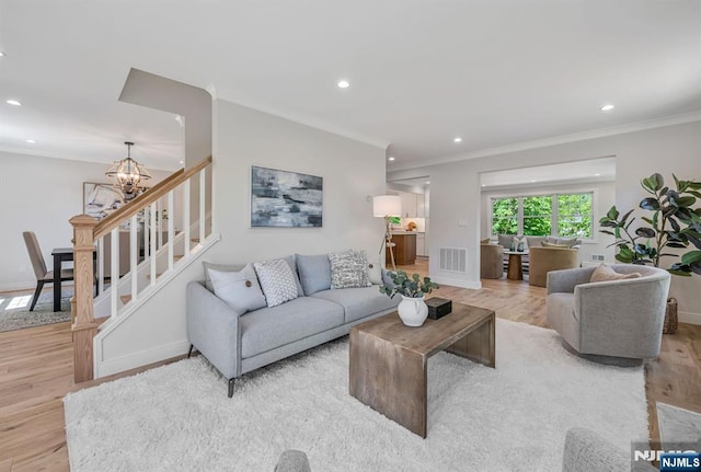 living area with visible vents, wood finished floors, baseboards, an inviting chandelier, and recessed lighting