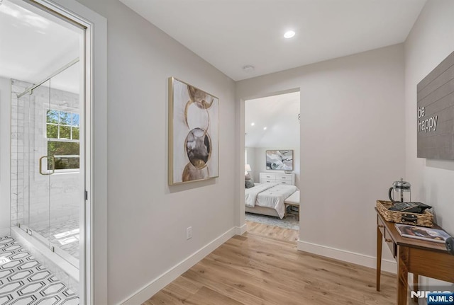 hall featuring baseboards, recessed lighting, and light wood finished floors