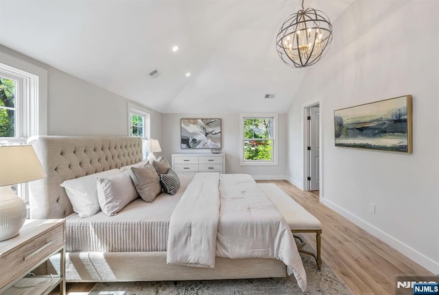 bedroom featuring visible vents, multiple windows, an inviting chandelier, and light wood-style floors