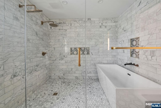 bathroom with a freestanding tub and a shower stall