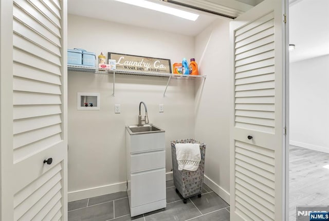 washroom with washer hookup, laundry area, tile patterned flooring, a sink, and baseboards