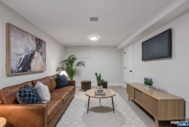 living area featuring light wood-style floors, baseboards, and visible vents