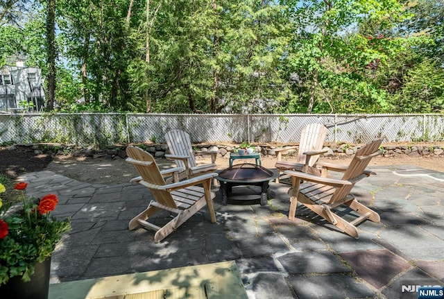 view of patio / terrace featuring fence and a fire pit