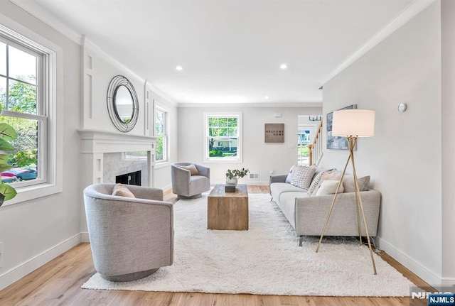 living area featuring visible vents, wood finished floors, baseboards, recessed lighting, and a premium fireplace