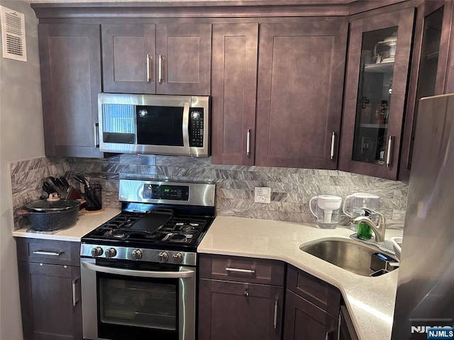 555 N Ave Unit 4C, Fort Lee, NJ 07024 - kitchen with visible vents, dark brown cabinetry, a sink, appliances with stainless steel finishes, and backsplash