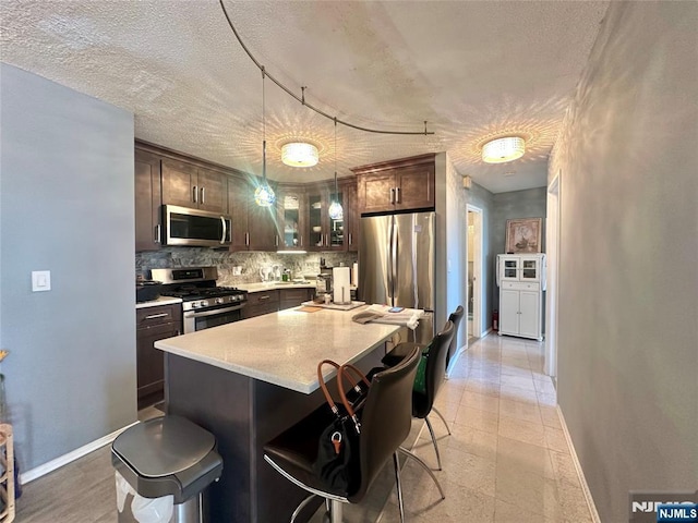 555 N Ave Unit 4C, Fort Lee, NJ 07024 - kitchen with stainless steel appliances, baseboards, decorative backsplash, and dark brown cabinets