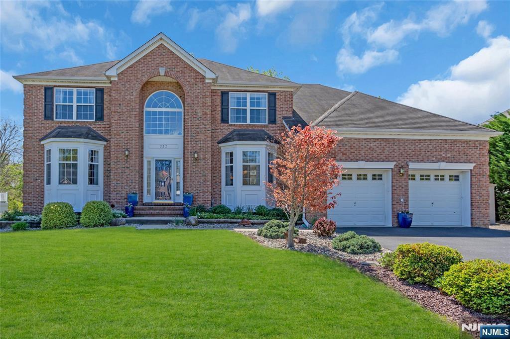 727 Maidenstone Dr, Brick, NJ 08724 - view of front of home featuring brick siding, an attached garage, and a front yard