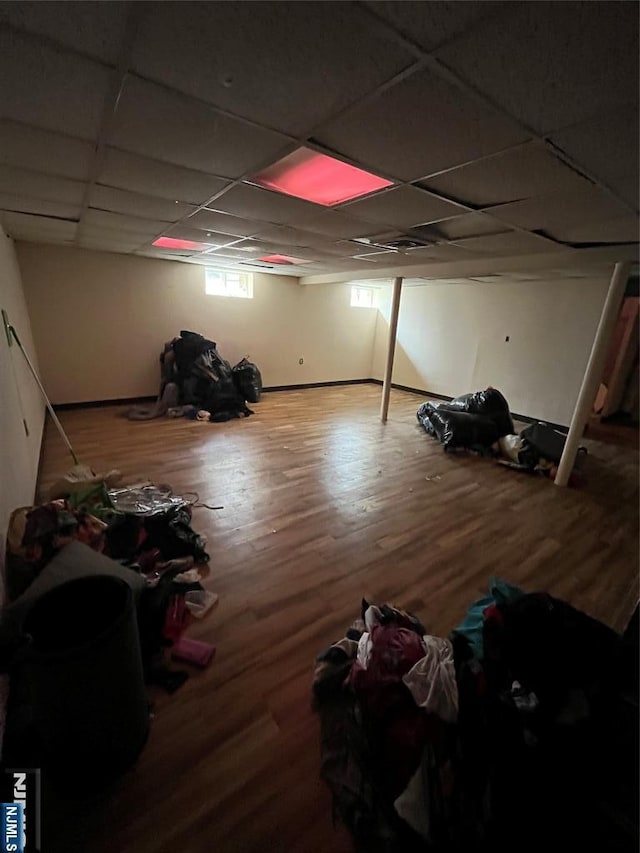 basement featuring wood finished floors and a paneled ceiling