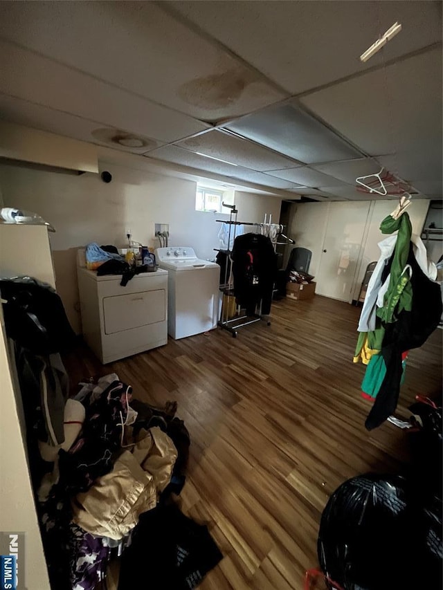 basement with wood finished floors, a paneled ceiling, and washing machine and dryer