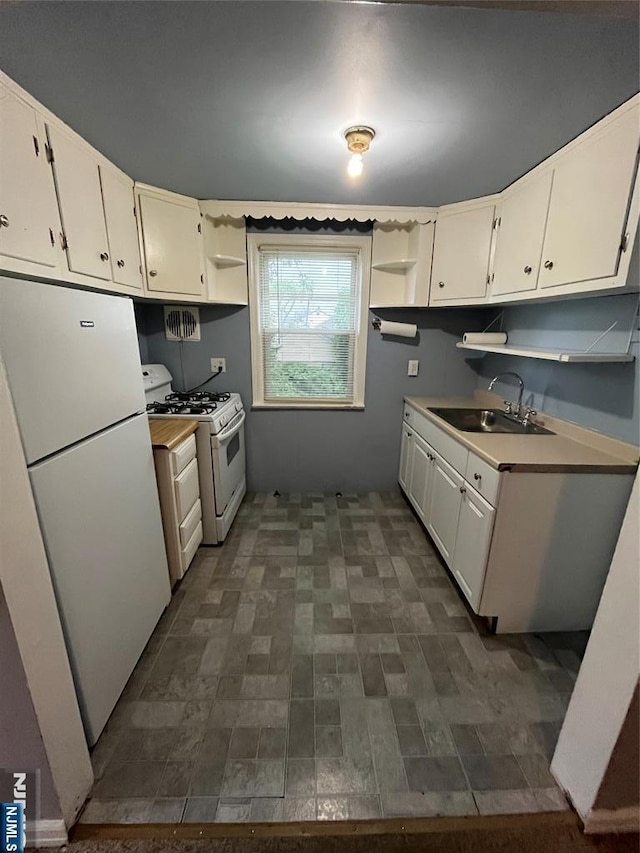 kitchen with open shelves, white appliances, light countertops, white cabinetry, and a sink