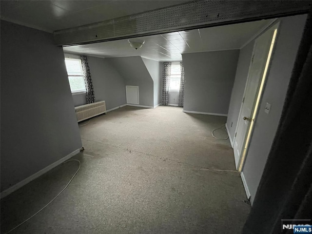 bonus room featuring baseboards and radiator