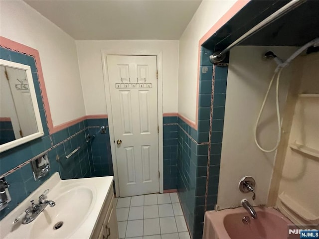full bath with tile walls, wainscoting, tile patterned floors, and shower / tub combination